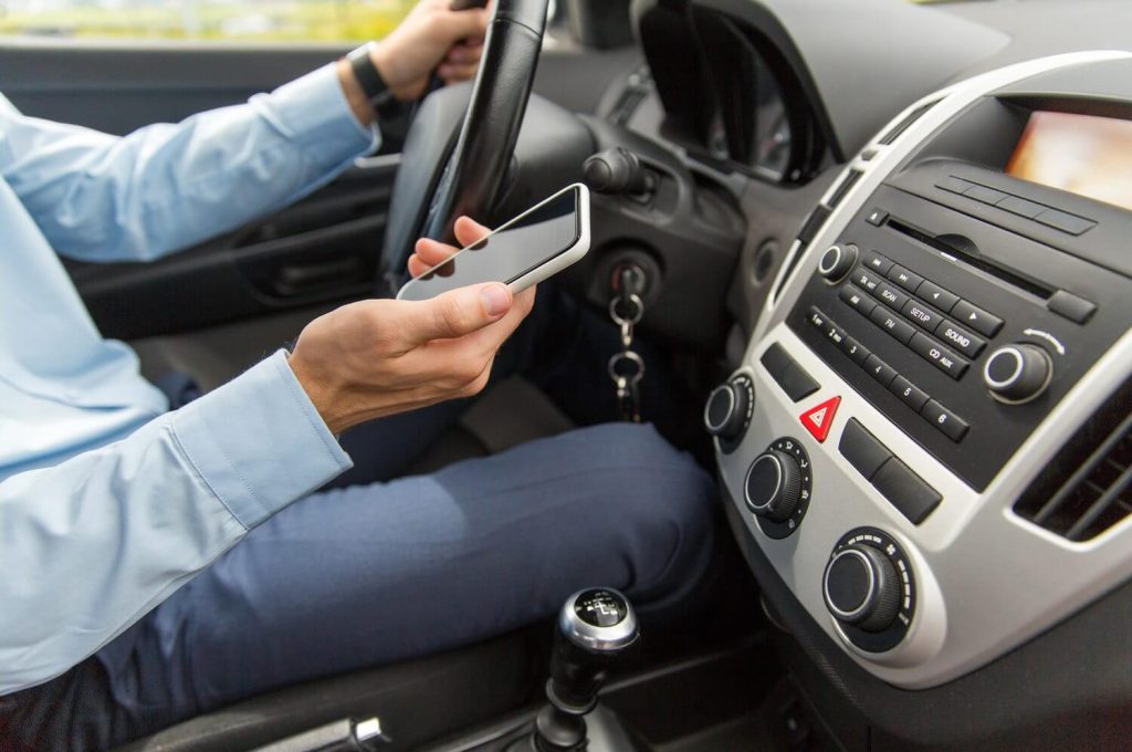 Driver distracted by phone behind the wheel, a leading cause of vehicle collision repair and auto body repair shop visits.